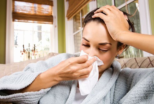natural cold remedies s1 woman blowing nose on couch